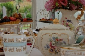 An afternoon tea with beautiful vintage china, table decorations and chair sashes.