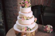 A Beautiful Four Tier weddig cake in a simple blush pink theme, decorated with fresh flowers, by The Daisy Chain Bakery