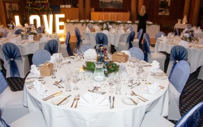 Kelham Hall, chair covers, navy organza hoods and hurricane vase centerpieces