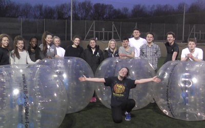 Group of Girls and Boys With Zorbs at a 18th Birthday Party with the Party Girl crouching in front of the group with her arms outstretch.