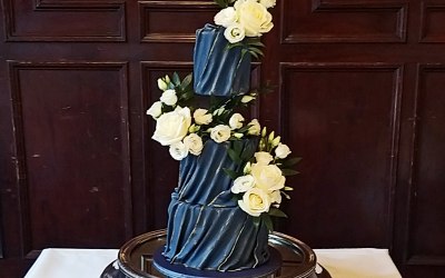 Navy blue and gold draped fondant wedding cake.