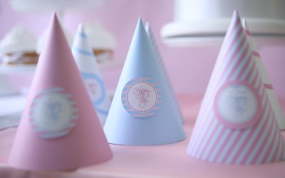 Pastel pink and blue party hats saying Happy day