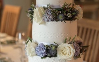 Three tier wedding cake with piping details and fresh flowers, 