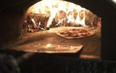 All Fired Up Pizzas - Fresh Pizza being cooked in the Wood Fired Oven