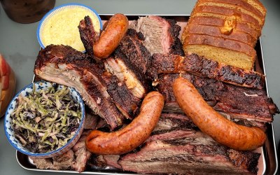 A tray of brisket, St Louis ribs, hot links, grits, Korean slaw, and beef fat brioche.