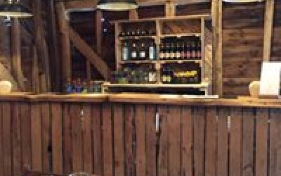 Rustic wooden bar at a wedding in a barn.