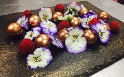 Mixed chocolate truffles with raspberries and edible flowers