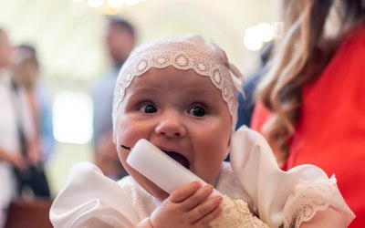 Baby Hilda munching on her Baptism candle at her special event!