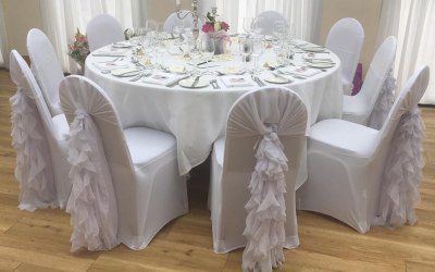 White chair covers with white chiffon hoods and ruffles