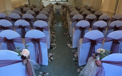White chair covers and burgundy organza sashes