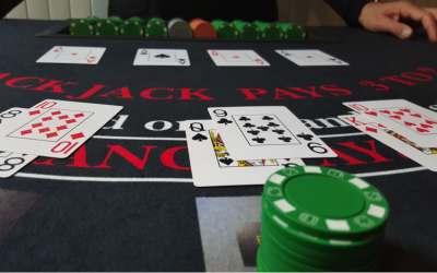 Table top view of chips, cards and one of our Croupiers dealing blackjack