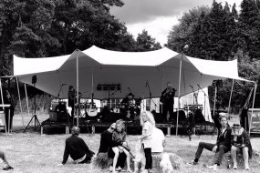 Pop up marquee tent protecting musical stage at outdoor event