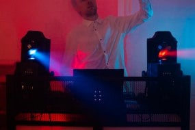 DJ dancing over his decks with colourful lights,