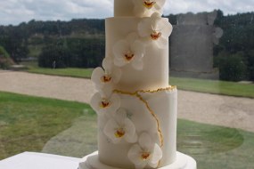 White, contemporary sugar orchids wedding cake with a touch of gold