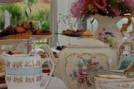 An afternoon tea with beautiful vintage china, table decorations and chair sashes.