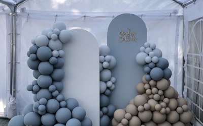 Balloon set up for a baby shower with custom medium and large sized boards accompanied by a 7ft balloon garland.