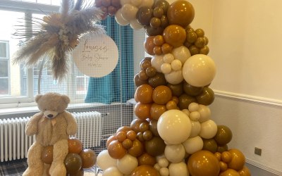 A neutral balloon display for a babyshower on a mesh hoop  