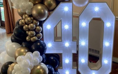 Organic balloon garland surrounding light up numbers 