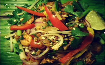 Spicy Prawns - Flat Rice noodles lightly chilli spiced with Spicy Prawns, beansprouts, Peppers and spring onions which is freshly wrapped and roasted in Banana Leaf (Vegetarian option available)