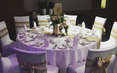 White chair covers and hessian with lace sashes and table runners