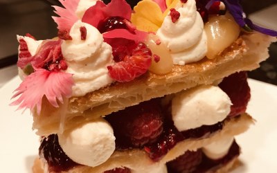 A decadent dessert of handmade lemon & Raspberry Millefeuille with edible flowers