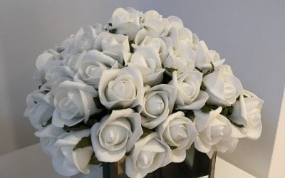 Mirror vase with bud roses table decoration from chair overtire Essex.co.uk