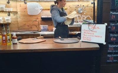 Lily hand stretching our pizza dough in our converted horsebox