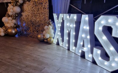 Gold sequin wall with xmas lights and balloon decor for corporate event