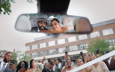 Creative wedding portrait capturing the couple’s big exit with guests celebrating around them. Creative wedding portrait capturing the couple’s big exit with guests celebrating around them.