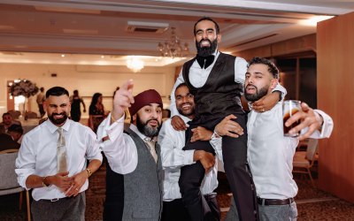 Groom lifted by groomsmen. Candid reception moment full of joy and energy. Groom lifted by groomsmen. Candid reception moment full of joy and energy.