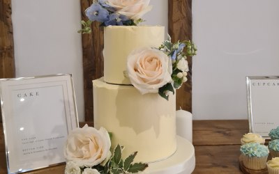 Buttercream weddings cake, blush, light blue and green flower arrangements 