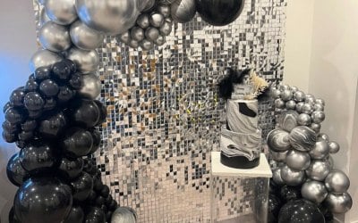 Hire of our mirror silver sequin wall with balloon garland and we hired in a clear acrylic cake stand from Glowing Events. Customer sourced own cake supplier.