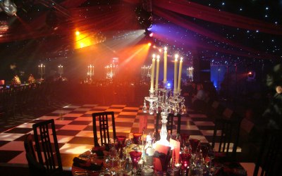 B & W dancefloor with an orange breakup wash across pin spotted tables