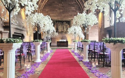 Peckforton castle dressed with blossom trees on stands, hurricane vases and petals
