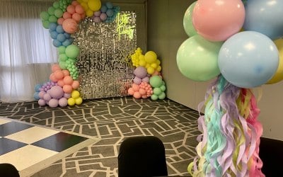 Hire of our mirror silver sequin wall with pastel balloon garland and ‘let’s party’ neon sign. We also provided air filled balloon table centerpieces.