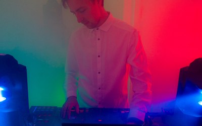DJ preparing next track with colourful lights,