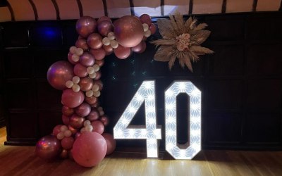 Light up numbers, balloon arch and floral piece