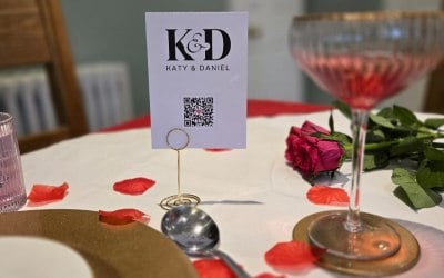 A6 Postcard sized Tap/Scan card supported by mid-height gold table card holder