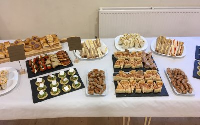 full finger buffet laid out on crockery, paddle, slate with signage