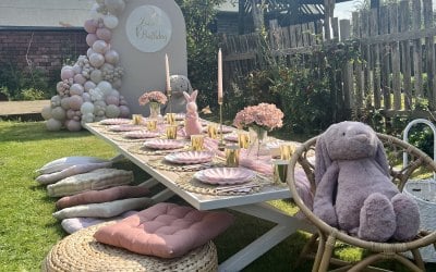 Silaboard personalised with balloon arch, giant bunny and picnic table set up for 12 children includes cushions, crockery & cutlery.