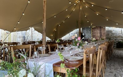 'Kingsdale' 10x15m stretch tent, set up with rustic furniture for wedding breakfast 