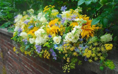 A long arrangement for a summer wedding in shades of yellow, blue and white