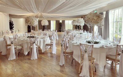 White elegant wedding venue styling with white rose centre pieces