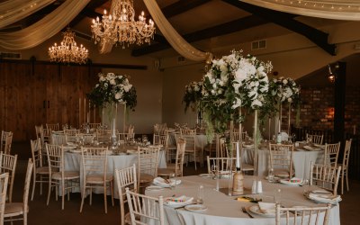 Tall white wedding table centre pieces with foliage