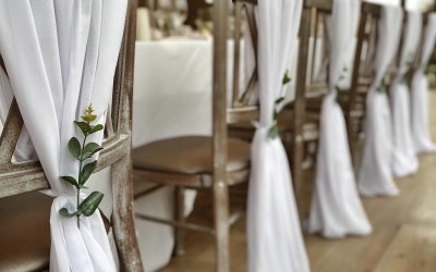 White chiffon chair drapes with eucalyptus sprigs