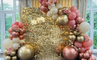 Gold Shimmer wall with a Balloon Garland  and neon sign
