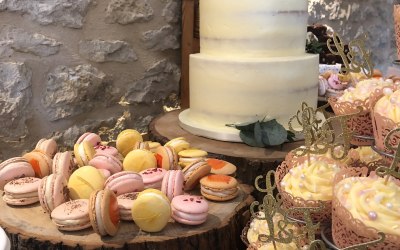 Mixed flavour macaron selection added to a dessert table at a wedding.