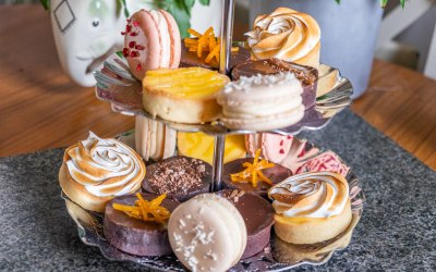 Tiered dessert selection including, raspberry, white chocolate and salted caramel macarons and chocolate orange, salted caramel, lemon curd and lemon meringue tarts.