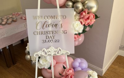 Easel welcome sign with balloon garland and flowers
