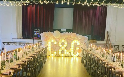 Light up letters with balloon wall and dressed wedding tables 